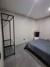 2 Bedroom Condo for Sale at Jomtien Beach Condominium second bedroom with bed and black wire shelving unit