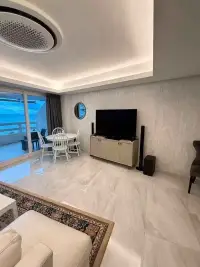 1 Bedroom Condo for Sale at Jomtien Complex living room with TV console, dining table and balcony sea view