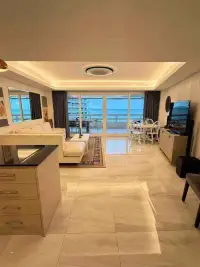 1 Bedroom Condo for Sale at Jomtien Complex open-plan living area with ocean view through glass balcony doors