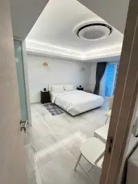 1 Bedroom Condo for Sale at Jomtien Complex bedroom with white bed, air conditioning unit and balcony access