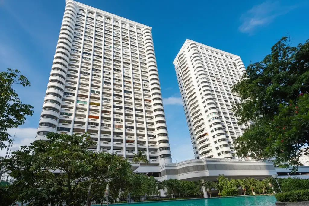 Jomtien Complex: Two tall, white residential towers with balconies against a blue sky, seen from a low angle.