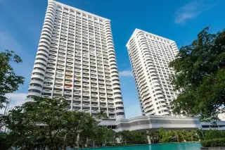 Jomtien Complex: Two tall, white residential towers with balconies against a blue sky, seen from a low angle.