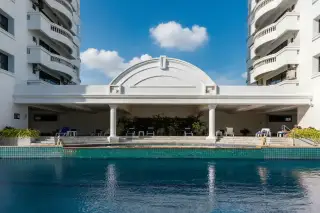 Jomtien Complex: Two tall, white residential towers with balconies against a blue sky, seen from a low angle.