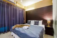 3 Bedroom House for Sale in Jomtien bedroom with king bed, wood paneled headboard, and blue curtains