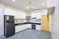 3 Bedroom House for Rent in Jomtien white kitchen with black countertops, oven and refrigerator