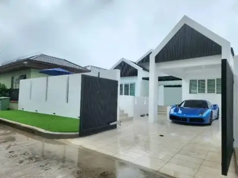 4 Bedroom House for Rent at Casa Jomtien exterior entrance with covered carport and sports car parked
