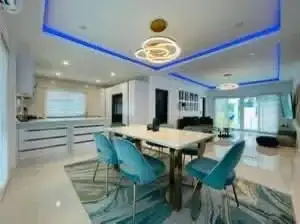 4 Bedroom House for Rent at Casa Jomtien open-plan dining area with turquoise chairs and kitchen view