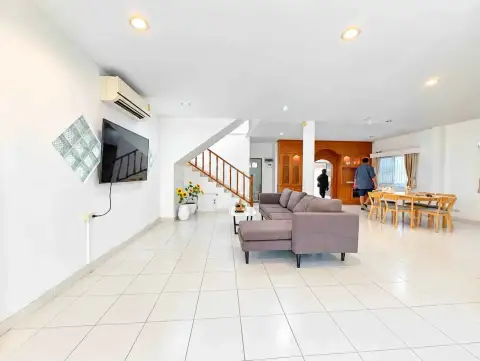 4 Bedroom House for Rent in Jomtien open-plan living room with sofa, staircase, and dining area
