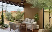 5 Bedroom House for Sale in Jomtien covered patio with rattan sofas and landscaped garden
