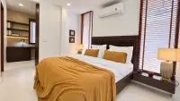 5 Bedroom House for Sale in Jomtien primary bedroom with carved wood headboard and mustard bedding