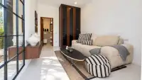 5 Bedroom House for Sale in Jomtien cozy sitting area with striped sofa and ensuite bathroom view