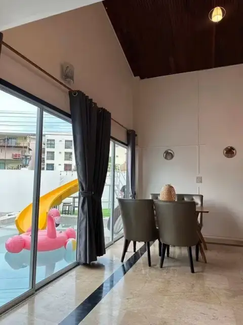 6 Bedroom House for Rent in Jomtien dining area with pool view and yellow water slide