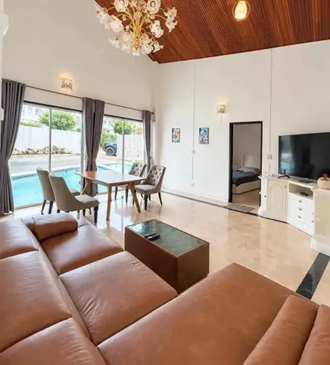 6 Bedroom House for Rent in Jomtien living room with leather sofas, dining table and pool view