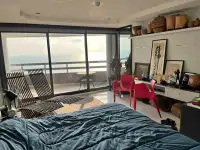 1 Bedroom Condo for Sale at Jomtien Plaza Condotel bedroom with ocean view balcony and wooden lounge chairs
