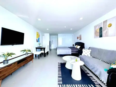 Studio Condo for Rent at Jomtien Plaza Condotel open-plan layout with bed, dining table, sofa, and TV