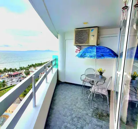 Studio Condo for Rent at Jomtien Plaza Condotel private balcony with table, chairs, umbrella, and sea view