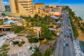 Jomtien Plaza Condotel: Aerial view of the condotel complex, Pattaya coastline, busy street, and ocean at sunset.