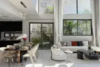 5 Bedroom House for Sale at The Lake Huay Yai spacious open-plan living and dining area with marble floors, black kitchen, and garden view