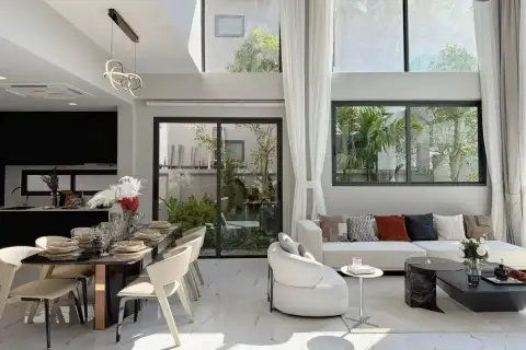 5 Bedroom House for Sale at The Lake Huay Yai spacious open-plan living and dining area with marble floors, black kitchen, and garden view