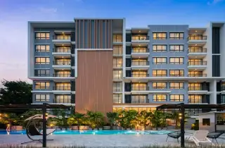 Cape Town Sriracha Condo Residence building exterior at dusk with illuminated pool and lounge area