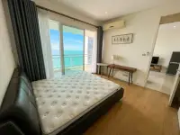 1 Bedroom Condo for Sale at Reflection Jomtien Beach bedroom with king bed and sea view balcony