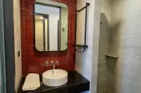 1 Bedroom Condo for Rent at EDGE Central Pattaya bathroom with round vessel sink, red mosaic tiles, mirror, and walk-in shower
