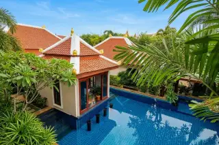 Temple Lake Villas: Overhead view of a blue tiled swimming pool next to a traditional Thai-style building with an orange roof, surrounded by lush green foliage.