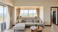 3 Bedroom Condo for Sale at Keha Thepprasit sitting area with sectional sofa, round coffee table and balcony access