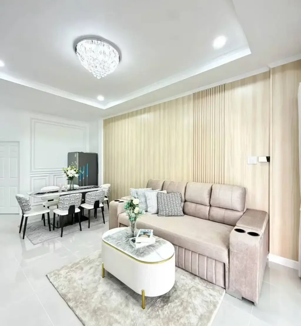 3 Bedroom House for Sale in East Pattaya open-plan living and dining area with beige sofa and chandelier