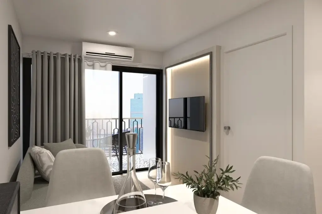 1 Bedroom Condo for Sale at The Indeed Condo Pattaya bright living room with sofa, wall-mounted TV, and balcony access