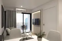1 Bedroom Condo for Sale at The Indeed Condo Pattaya bright living room with sofa, wall-mounted TV, and balcony access