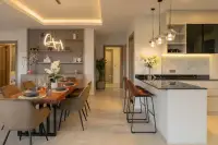4 Bedroom House for Sale at Zensiri Lakeside Pool Villas dining area with wooden live-edge table and kitchen island with dark marble countertop