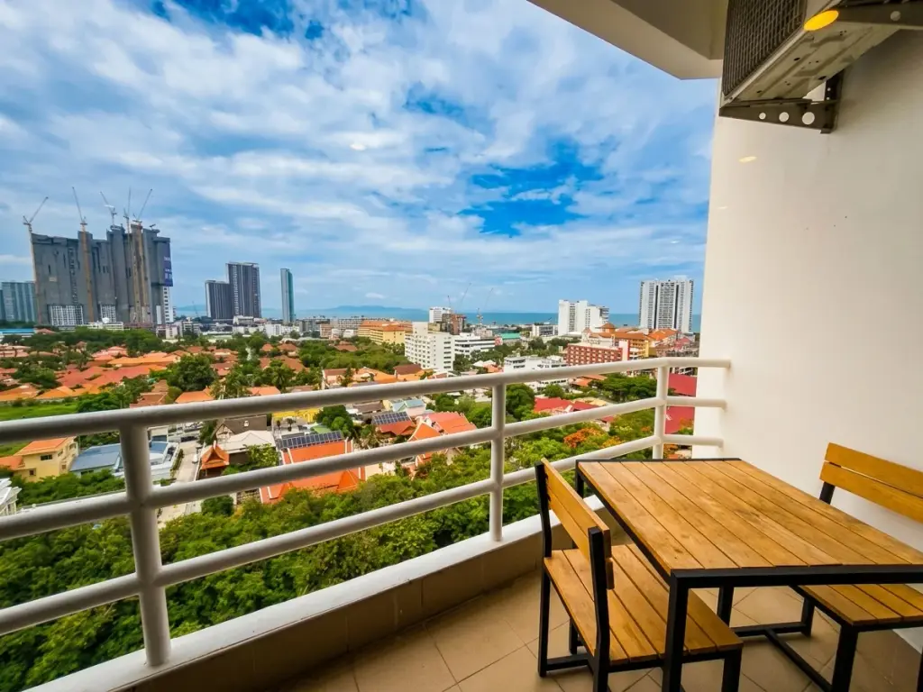 1 Bedroom Condo for Sale at View Talay 2 balcony with wooden table, chairs and high-rise city skyline view