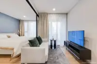1 Bedroom Condo for Sale at Aquarous Jomtien Pattaya: Kitchenette with built-in appliances, washing machine, and living area view.