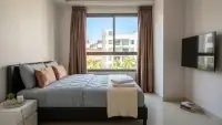 2 Bedroom Condo for Sale at Arcadia Beach Resort bedroom with wall-mounted TV and city view window