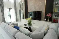 4 Bedroom House for Sale in Nong Prue stylish living room with grey sectional sofa and textured TV feature wall