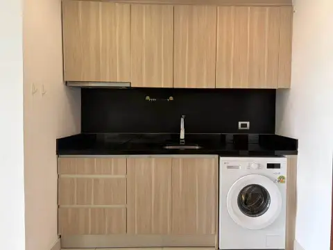 1 Bedroom Condo for Sale at Laguna Beach Resort 1 kitchenette with black countertop, sink, and built-in washing machine