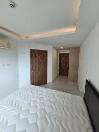1 Bedroom Condo for Sale at Laguna Beach Resort 3 (The Maldives) bedroom with mattress, wardrobe, and hallway to wooden doors