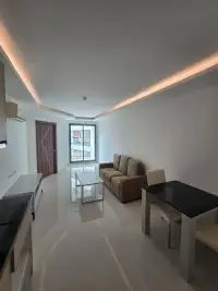 1 Bedroom Condo for Sale at Laguna Beach Resort 3 (The Maldives) living and dining area with sofa, table, and city view window