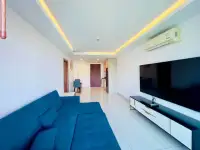 1 Bedroom Condo for Sale at Laguna Beach Resort 3 (The Maldives) living room with blue sofa and wall-mounted TV