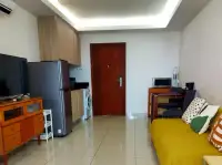 1 Bedroom Condo for Sale at Laguna Beach Resort 1 living space with yellow sofa, wooden door, and kitchenette