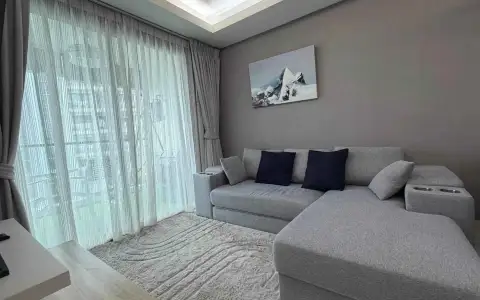 2 Bedroom Condo for Rent at Laguna Beach Resort 1 gray sectional sofa with navy pillows beside sheer curtained balcony door