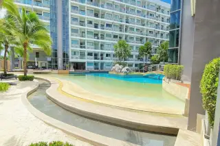 Laguna Beach Resort 1 large lagoon-style swimming pool with a bridge, artificial beach, and multi-story building.