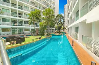 Laguna Beach Resort 1 long, narrow swimming pool between two condo buildings, with artificial grass and loungers.