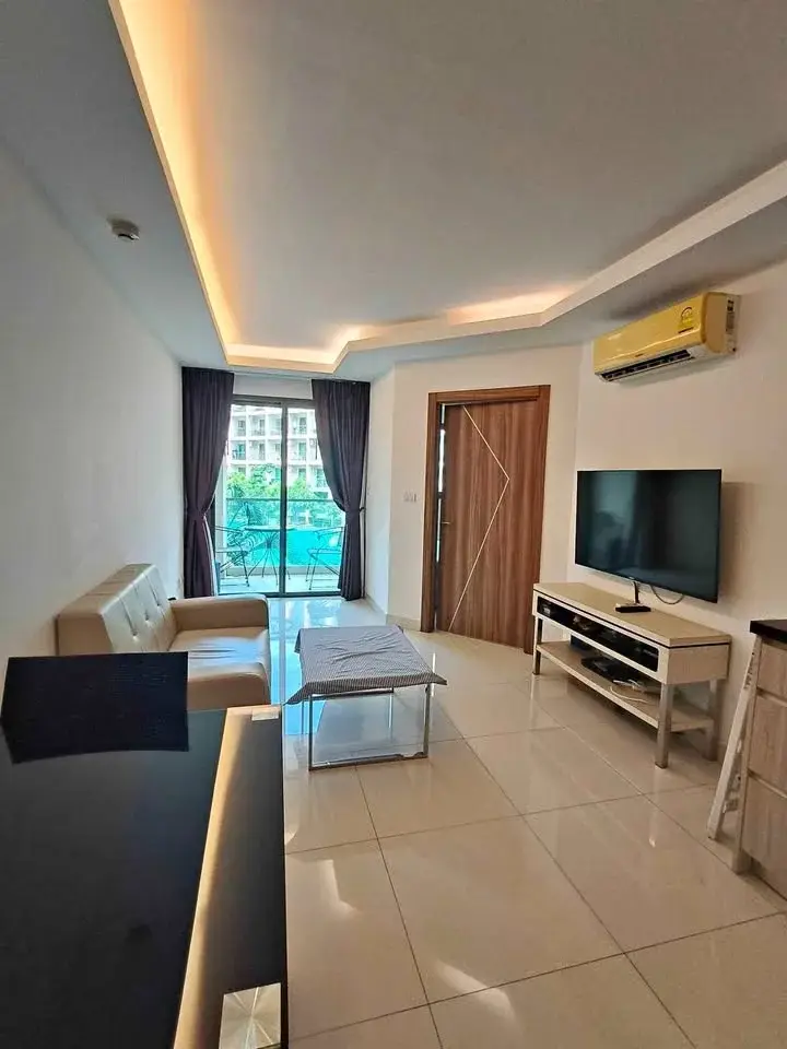 1 Bedroom Condo for Rent at Laguna Beach Resort 2 living room with leather sofa, TV unit, and balcony pool view