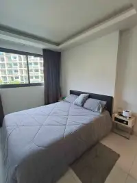 1 Bedroom Condo for Rent at Laguna Beach Resort 2 bedroom with window view of resort buildings and nightstand