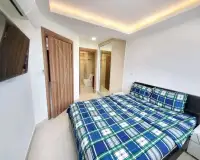 1 Bedroom Condo for Rent at Laguna Beach Resort 3 (The Maldives) bedroom with plaid bedding, TV and en-suite bathroom