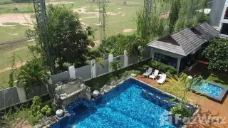 Lanna Condo bedroom with wooden sliding wardrobe and floral accent wall in Pattaya