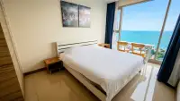 2 Bedroom Condo for Sale at The Riviera Jomtien bedroom with ocean view balcony and wall art