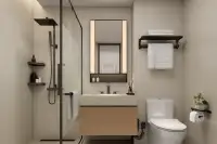 Studio Condo for Sale at Level Pratumnak bathroom with glass shower, wood vanity and backlit mirror